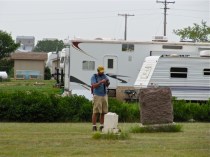 Field crew member Professor Holmgren (of Franklin and Marshall College, PA) documents a historic cemetery surrounded by a Type II camp just south of Tioga, ND in August 2012.