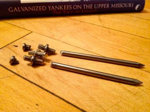 Non-galvanized nails cut to book-shelf peg length in front of Michele Butts, "Galvanized Yankees on the Upper Missouri: The Face of Loyalty" (University Press of Colorado, 2003).