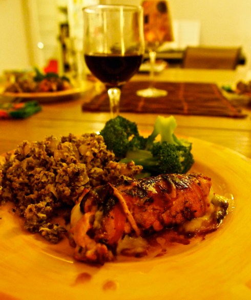 The plated meal. We ended up finishing the roulade in the oven after putting a char on it with the grill. Wild rice-mushroom hot dish to the left, and steamed broccoli above, this just below a bit of table red.